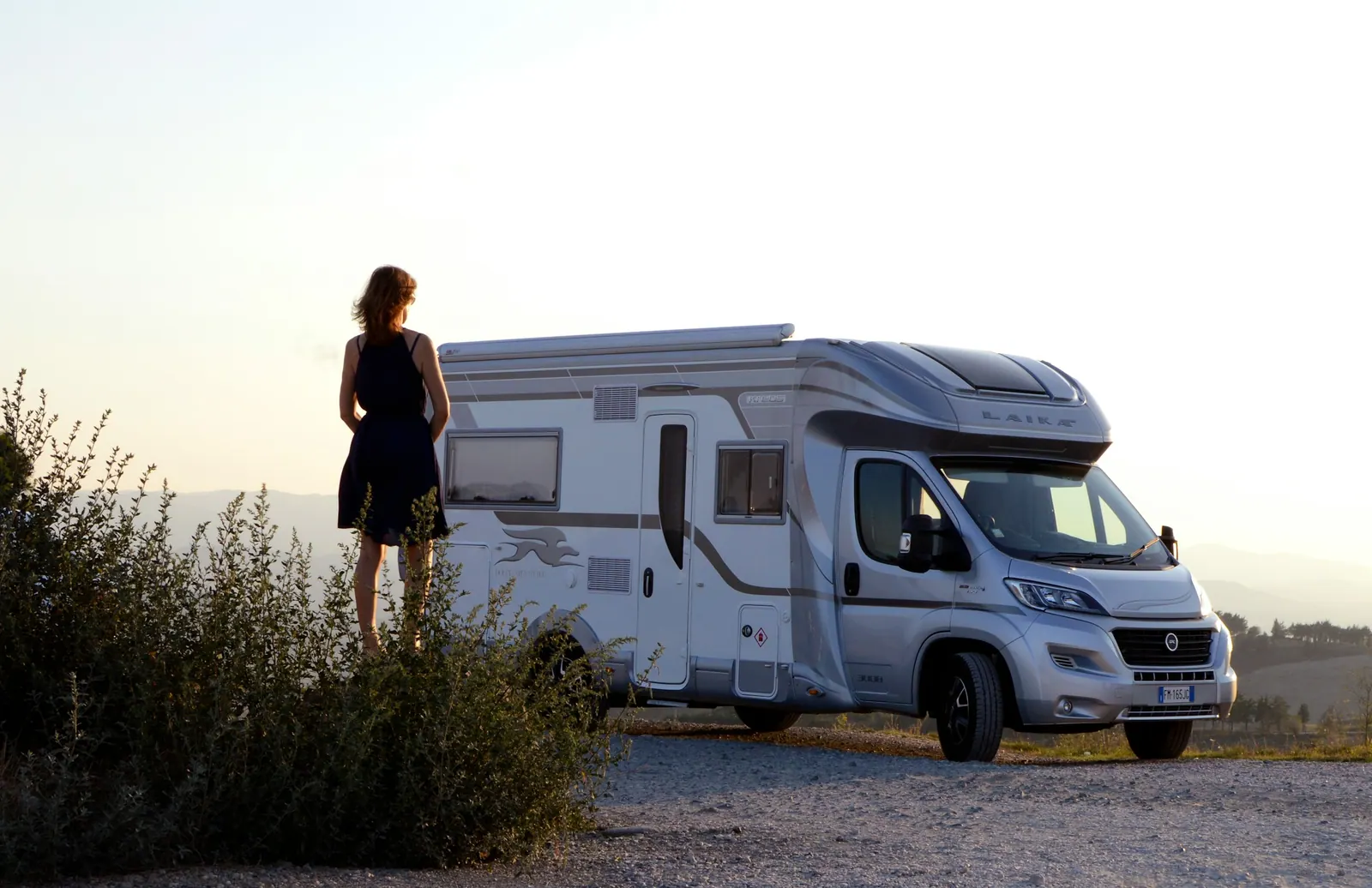 Modernes Wohnmobil in offener Landschaft bei Sonnenuntergang